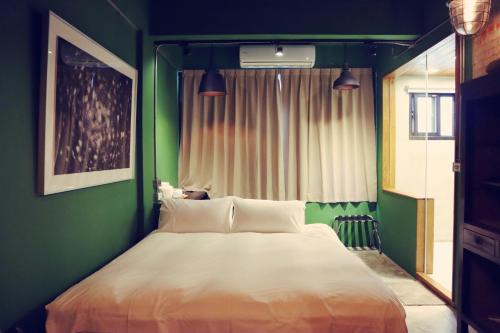 花莲市旅充人文的一间卧室设有一张大床和绿色的墙壁