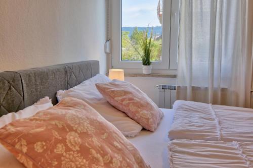 伊佐拉Bellevue的卧室配有带枕头的床铺和窗户。
