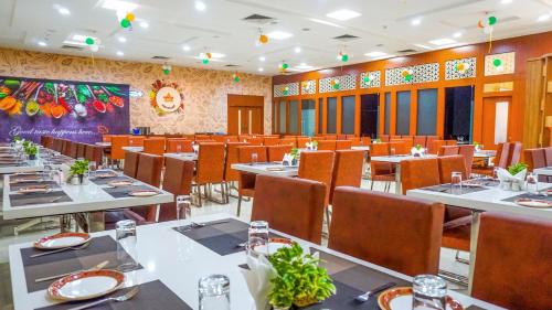 维沙卡帕特南Hotel Ambicas Grand的餐厅内带桌椅的用餐室