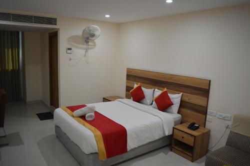 维沙卡帕特南Hotel Ambicas Grand的一间卧室配有一张带红色枕头的大床