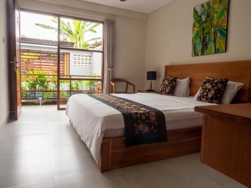沙努尔House of Michella - Modern, Quiet & Central的一间卧室设有一张大床和一个大窗户