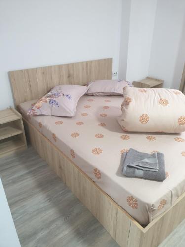 阿尔杰什河畔库尔泰亚Pensiunea Valea Veveritelor的一张带木制框架和枕头的大床