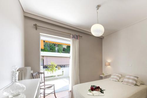 雅典Central Halandri apartment near all hospitals的一间卧室配有一张床、一张桌子和一个窗户。