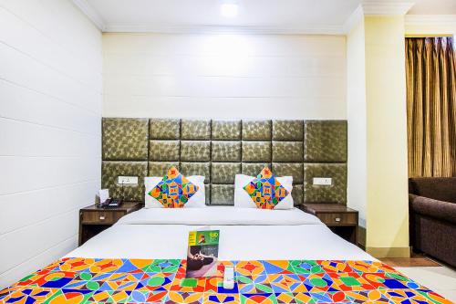 阿姆利则FabHotel Aaykay Model Town的酒店客房,配有一张带彩色床罩的床