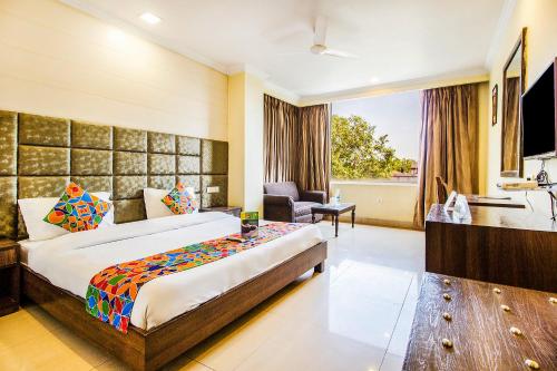 阿姆利则FabHotel Aaykay Model Town的酒店客房设有一张大床和一间浴室。