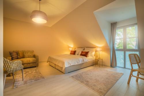 斯图帕瓦Arkady Hof Hotel的卧室配有床、椅子和窗户。