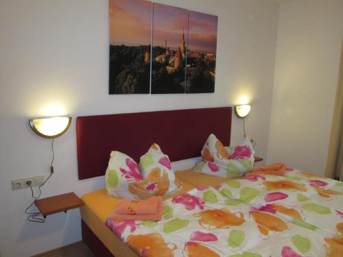 Schwenningen温浩思昂格尔宾馆的一间卧室配有一张床、两盏灯和一幅画