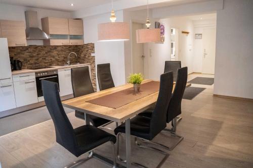 温特贝格诺尔德航维拉公寓的厨房以及带木桌和椅子的用餐室。