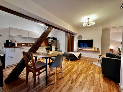 Modernes Apartment mit besonderem Charme - 1A Guesthouse的厨房以及带桌椅的起居室。