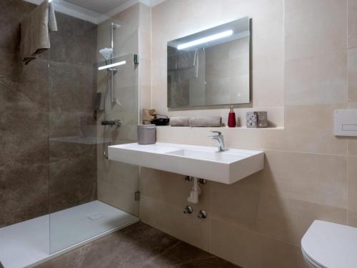 弗尔克马克特Jagerwirt rooms的浴室配有盥洗盆和带镜子的淋浴