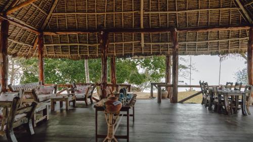 KengejaPemba Eco Lodge的一间带桌椅的餐厅和一个大型凉亭