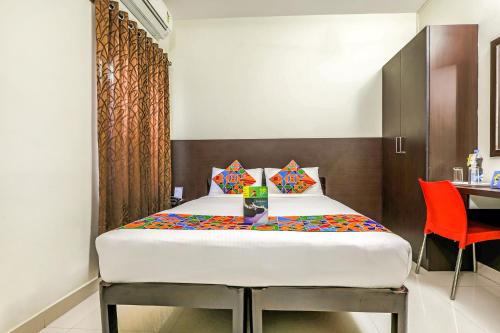班加罗尔FabHotel RMS Comforts Yeshwantpur的卧室配有1张床、1张桌子和1把椅子