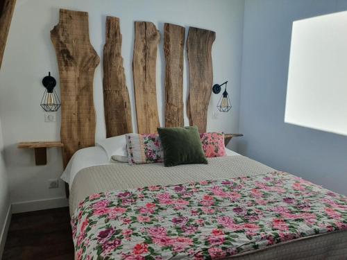 AmanlisGîte le talus的一间卧室配有一张带粉红色花卉床头板的床