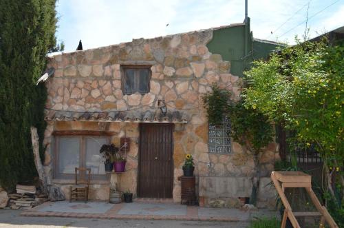 瓦伦西亚Granja El Regajo的一座古老的石头房子,有一扇门和一扇窗户