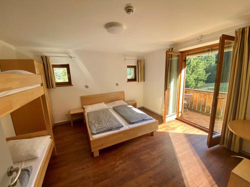 施利尔塞BLSV Sportcamp direkt im Wandergebiet Spitzingsee的一间卧室设有一张床和一个阳台