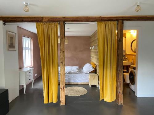 塞济斯菲厄泽Steinholt, charming & just renovated apartment !的一间卧室配有黄色窗帘的床