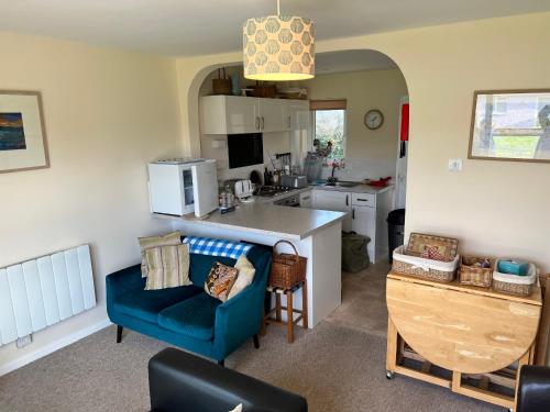 海景城2 Bedroom Bungalow SV58, Seaview, Isle of Wight Free Wi-Fi的厨房配有蓝色的沙发和蓝色的椅子