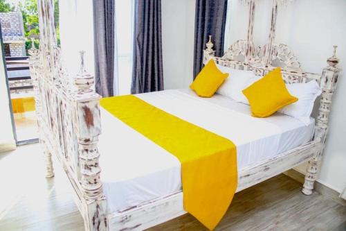 蒙巴萨Shany’s Villa 3bdrm with private swimming pool的客房内的白色床和黄色枕头