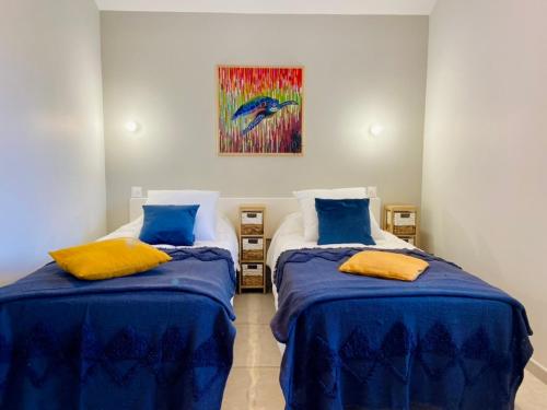Lachapelle-sous-AubenasMas de Veyras - Gîtes 5 étoiles en Ardèche的一间卧室配有两张带蓝色床单和绘画的床。
