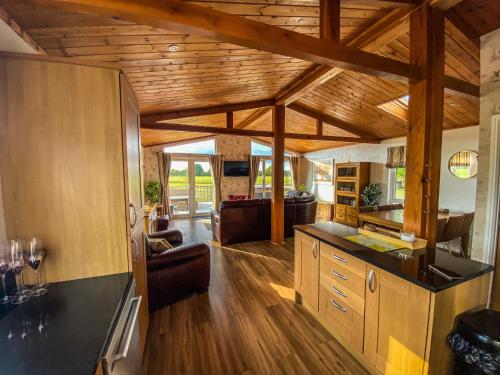 约克Immaculate 3-Bedroom Private Lodge near York的厨房和客厅设有木制天花板。