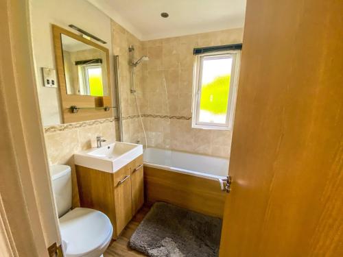 约克Immaculate 3-Bedroom Private Lodge near York的一间带卫生间、水槽和镜子的浴室