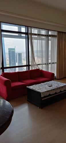 吉隆坡Ts service suites at Times Square的客厅设有红色的沙发和大窗户