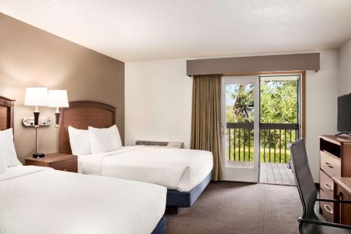 Baudette包地特阿美瑞辛套房酒店的酒店客房设有两张床和一个阳台。