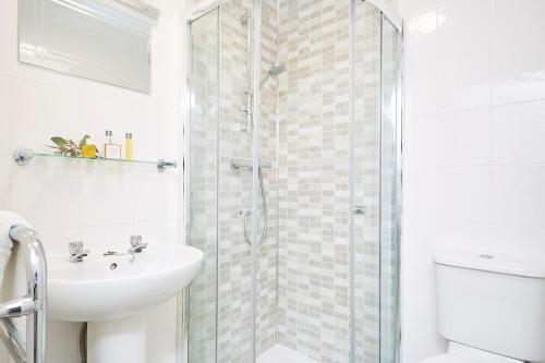 尚克林卢康蓓庄园乡间别墅酒店的带淋浴和盥洗盆的白色浴室