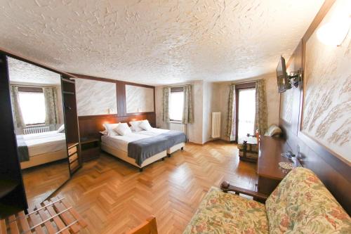布勒伊-切尔维尼亚HOTEL SPORTING的一间卧室配有一张床和一张沙发