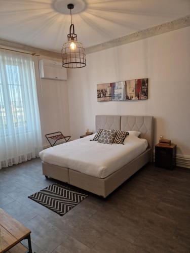 科尔马Hipster suites - Chez Axelle -的一间卧室配有一张床和一个吊灯