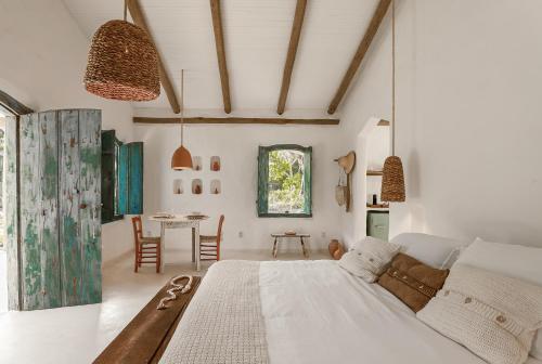 马劳Vila Oyá - praia de algodões的一间卧室配有一张大床和一张桌子