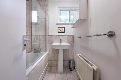 伦敦Stay in Islington in style 3BDR apt Nr Upper St的白色的浴室设有水槽和淋浴。