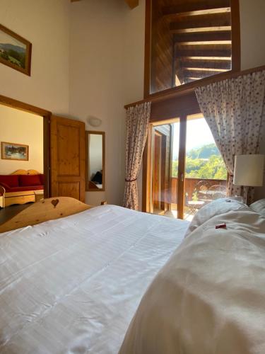 瓦尔·蒂利兹Apparthotel Mountain River Resort的卧室设有一张大白色的床和大窗户