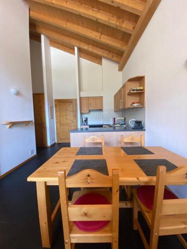 瓦尔·蒂利兹Apparthotel Mountain River Resort的厨房配有木桌和椅子