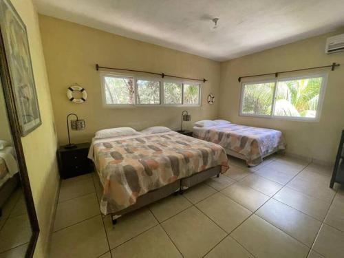 蒙特里科Casa Los Cocos Monterrico的一间卧室设有两张床和两个窗户。