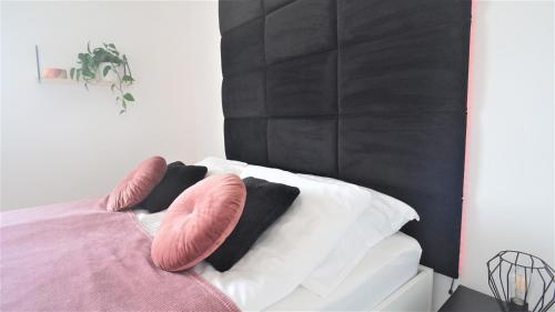 绿山城Apartament Silesia的床上配有粉色和白色枕头的床