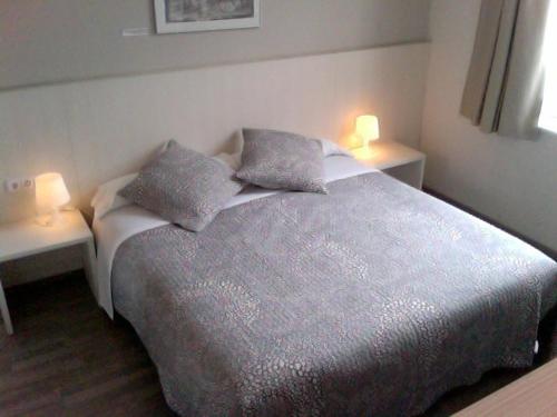 维克北站酒店的一间卧室配有一张带两个台灯的床,