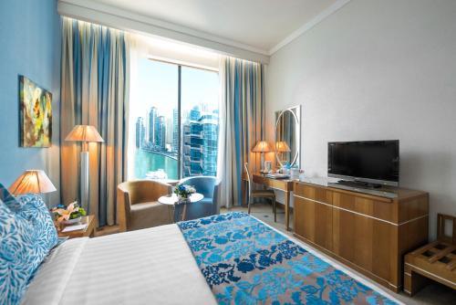 迪拜玛立纳比布鲁斯酒店的配有一张床和一台平面电视的酒店客房