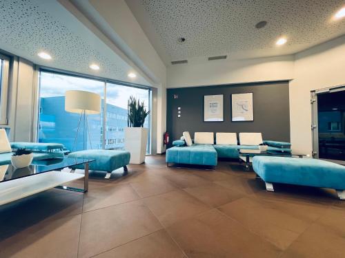 Neuhausen ob EckAircraft Hotel & Events的客厅配有蓝色的家具和大窗户