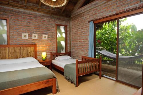 阿亚姆佩El Campito Lodge的一间卧室设有两张床和大窗户