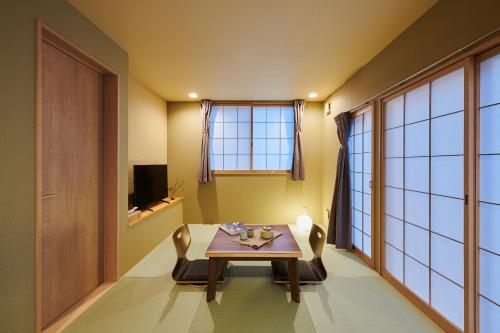 大阪俪居花园酒店Reikyo Garden Hotel的一间带桌椅和窗户的用餐室