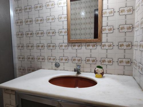 圣佩德罗-达阿尔德亚Casa pé na areia - 4m da praia!的一间带水槽和镜子的浴室