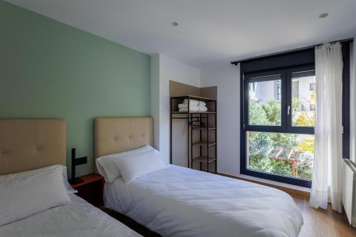 洛格罗尼奥Apartamentos Congreso, Parking gratuito的带窗户的客房内的两张床