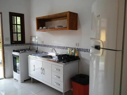 伊利亚贝拉Chalés Azuleto - Ilhabela的厨房配有水槽和冰箱