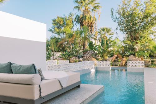 法里拉基Kouros Exclusive Hotel & Suites - Adults Only的客厅设有沙发,毗邻游泳池