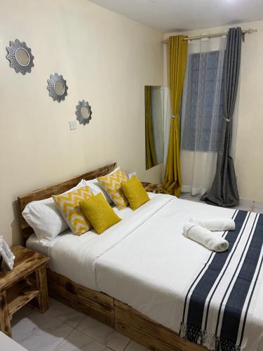 尼耶利Ruby Modern Homes-2br-Nyeri, King'ong'o-Knights的一间卧室配有一张大床,提供黄色和蓝色的枕头
