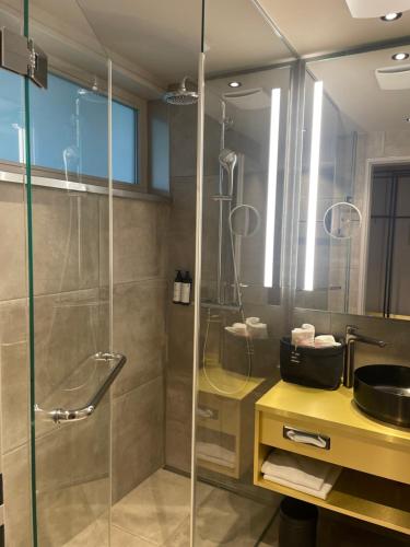 慕尼黑Scheck Hotel的一间带玻璃淋浴和水槽的浴室