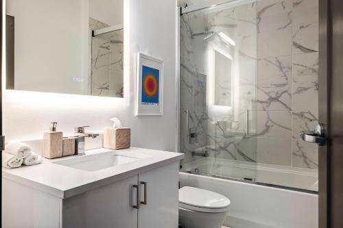 安娜堡Exhibit A2的白色的浴室设有水槽和淋浴。