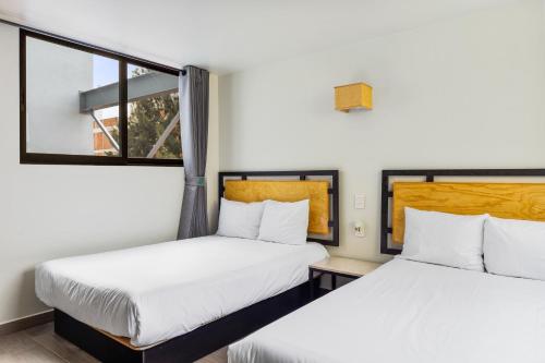 墨西哥城Lago Zirahuén By HomiRent的带2扇窗户的客房内的2张床