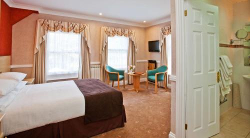 圣马丁格恩西La Villette Hotel的酒店客房带一张床、一张桌子和椅子